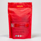 The back of the Nelzh Tea Organic Raspberry Green Zest bag, displaying company information, a QR code, and a list of organic ingredients including Chumnee tea, hibiscus, and raspberry.