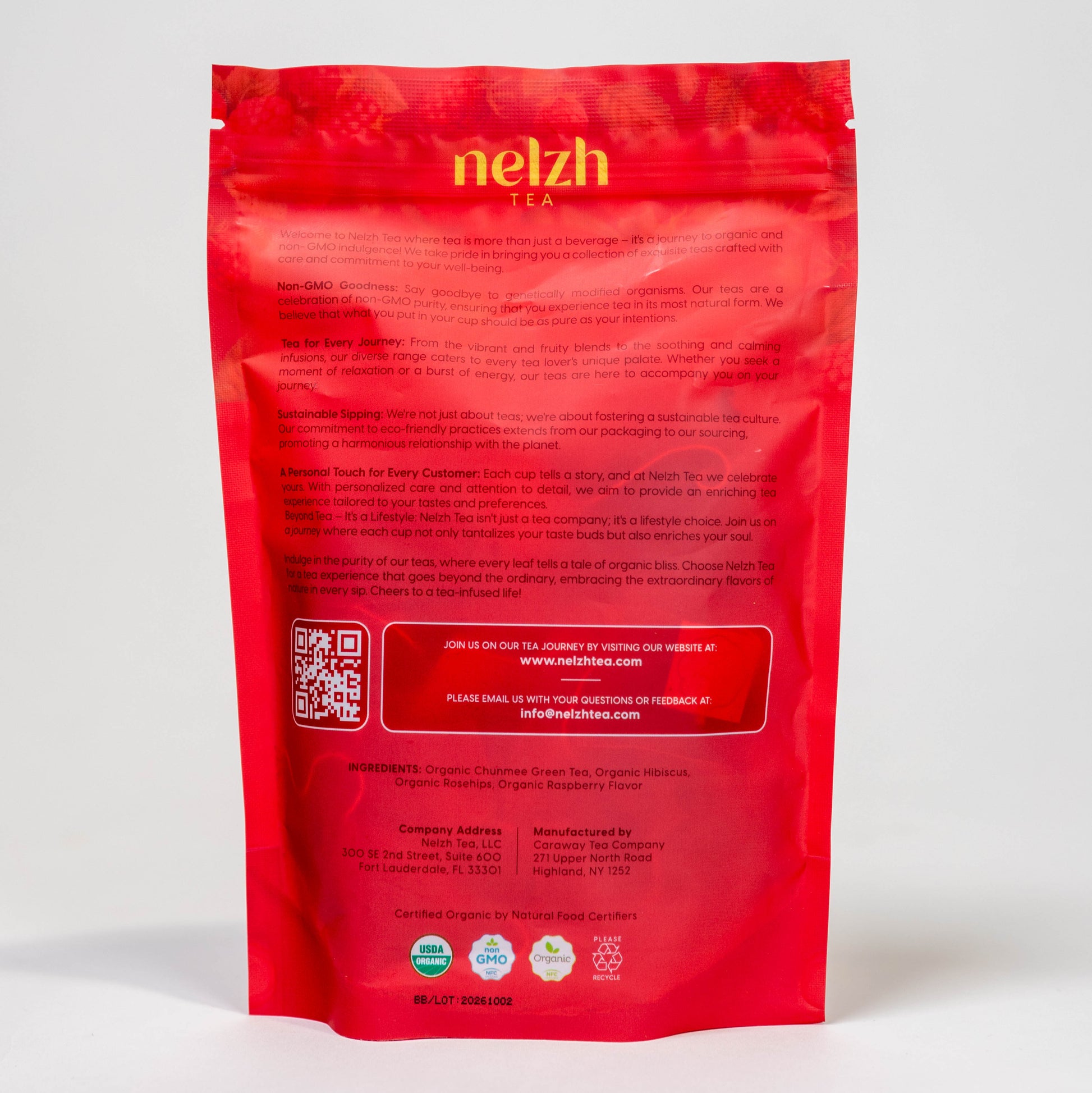 The back of the Nelzh Tea Organic Raspberry Green Zest bag, displaying company information, a QR code, and a list of organic ingredients including Chumnee tea, hibiscus, and raspberry.