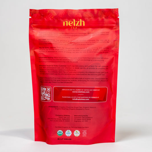 The back of the Nelzh Tea Organic Raspberry Green Zest bag, displaying company information, a QR code, and a list of organic ingredients including Chumnee tea, hibiscus, and raspberry.
