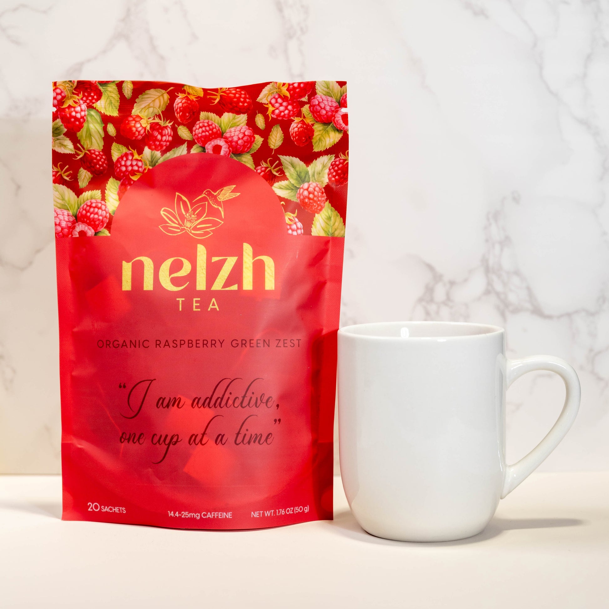 A red pouch of Nelzh Tea Organic Raspberry Green Zest, containing 20 sachets of organic raspberry and green tea blend.